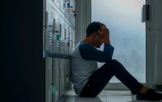 Stressed Man sitting on floor holding head