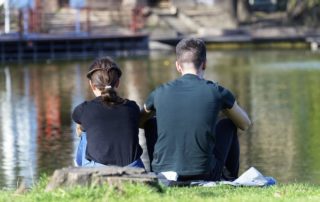 Couple sitting by lake