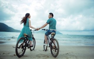Couples riding bikes on a beach