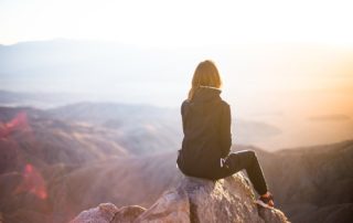 Woman sitting looking at mountains